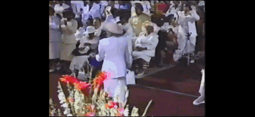 a woman in a white hat stands in front of a large crowd