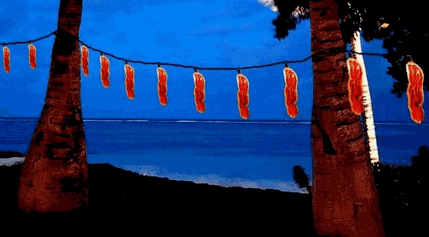 a painting of palm trees with a string of red lights hanging from them
