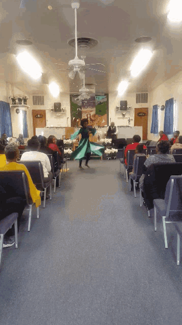 a woman dancing in front of a crowd in a church