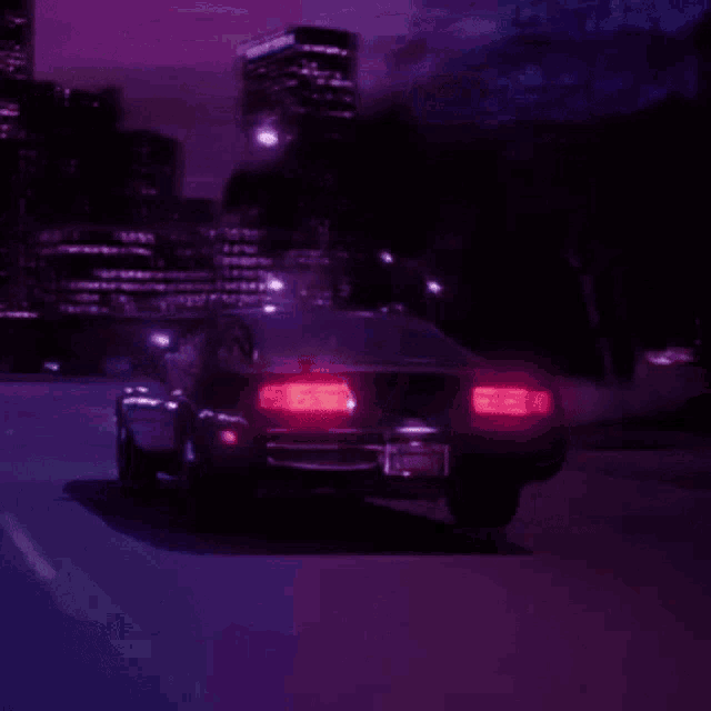 a car is driving down a road at night with a purple sky in the background