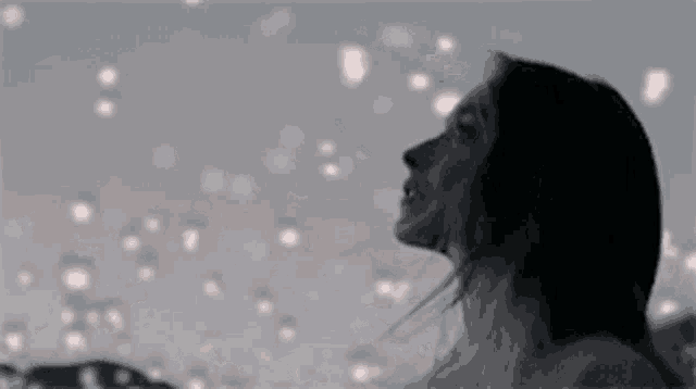 a woman is standing in front of a field of lights and looking up at them .