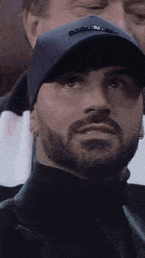 a man with a beard wearing a hat that says dsquared on it