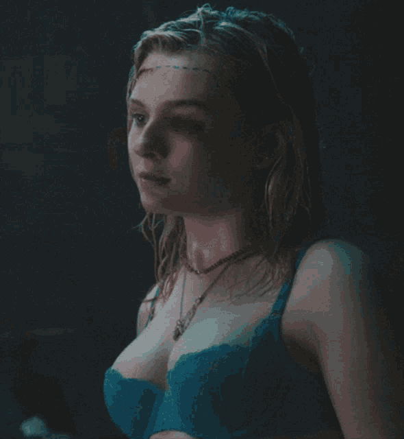 a woman wearing a blue bra and a red necklace