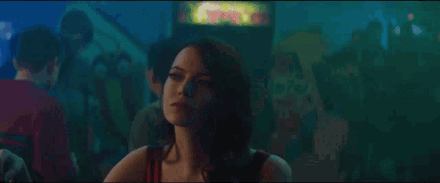 a woman in a red tank top is sitting in front of an arcade machine with the word doughnuts on it