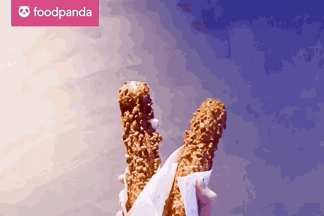 a person is holding two food sticks in front of a food panda logo