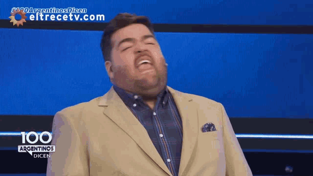 a man in a tan suit stands in front of a blue background that says 100 argentinas dicen