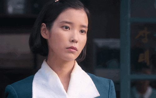 a woman wearing a white collar and a blue jacket