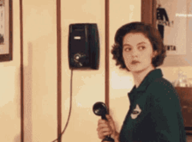 a woman in a green shirt talking on a phone