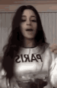 a woman with long dark hair is wearing a white sweatshirt with the word aa on it .