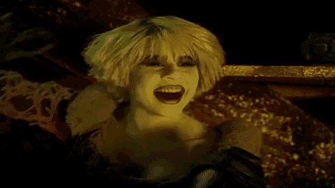 a woman in a wig is screaming with her mouth open .
