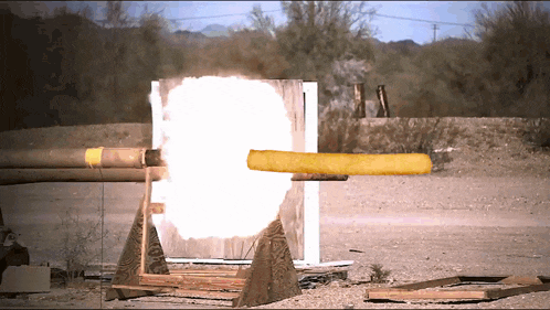 a bullet is being fired through a wooden barrier