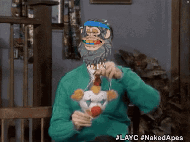 a man in a green sweater with a monkey mask on his face eating food