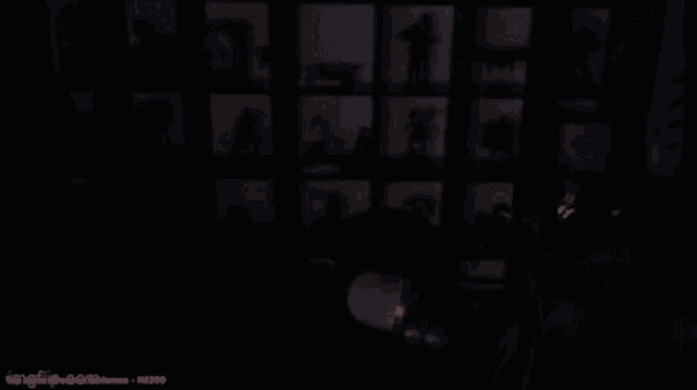 a man wearing glasses is sitting in a dark room with the words tak ses uplenej curak written on the screen .