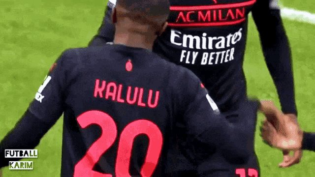 a soccer player wearing a black jersey with emirates fly better written on it