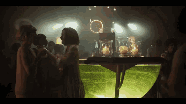 a group of people are dancing in a dark room