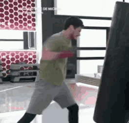 a man is boxing in a gym with a punching bag .