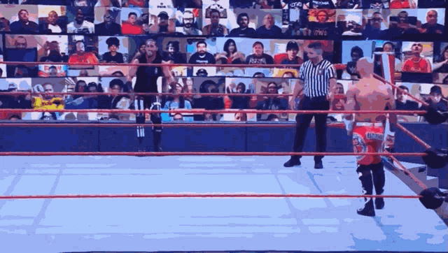 a wrestling ring with a referee and a wrestler wearing a shirt that says ' reigns '