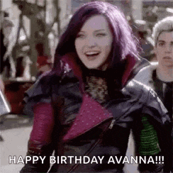 a woman with purple hair is wearing a leather jacket and smiling while walking down a street .