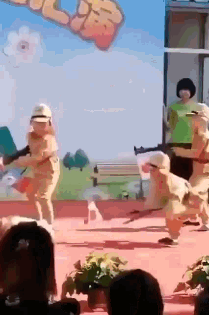 a group of children dressed up as beekeepers are holding guns on a stage