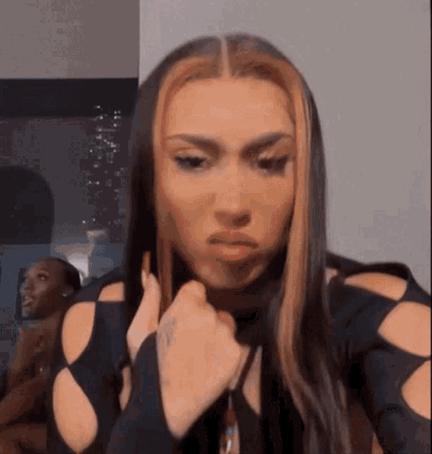 a woman with long hair and a nose ring is making a face .