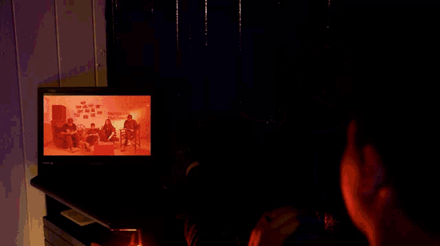 a group of people standing in a dark room with hebrew writing on the bottom right