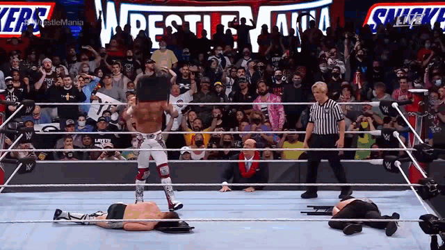 a wrestler in a wrestling ring with a snickers sign behind him