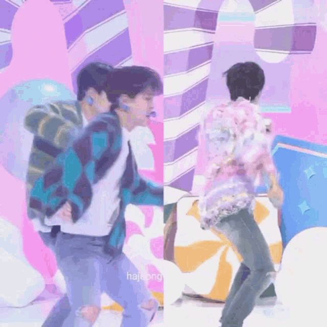two men are dancing on a stage in front of a pink and purple wall .