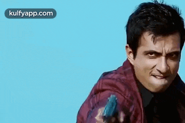 a man is holding a gun in his hand and making a face .