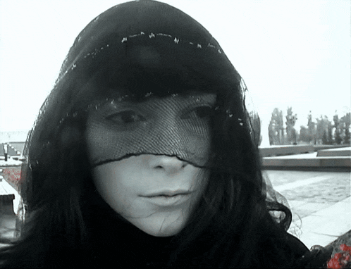 a black and white photo of a woman wearing a mask