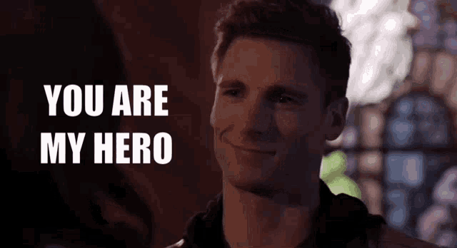 a man is smiling with the words " you are my hero " behind him