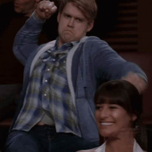 a man in a plaid shirt is standing next to a woman