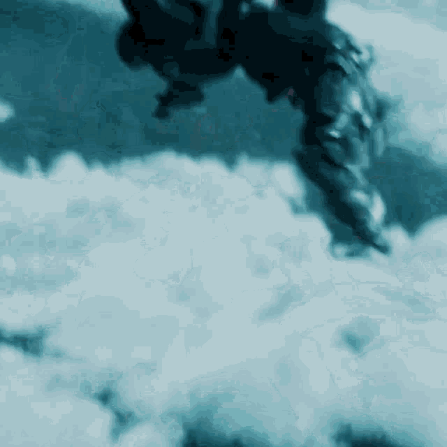 a blurred image of a man riding a motorcycle in the sky