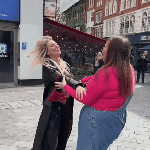 two women are dancing in front of a restaurant named ristorante roma