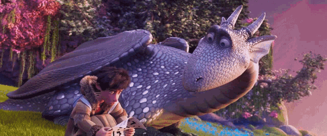 a boy sits next to a dragon with the number 13 on it 's back
