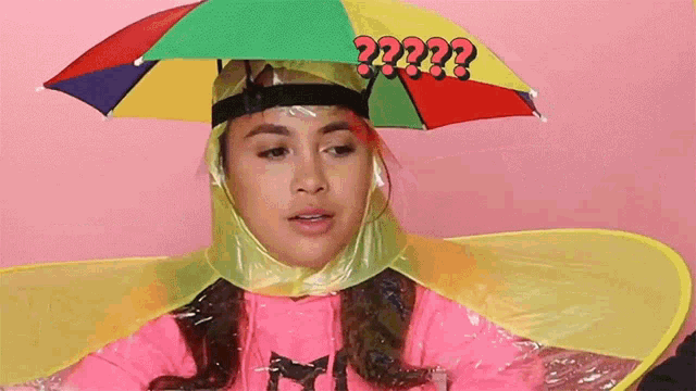 a girl wearing a colorful umbrella on her head with a question mark above it