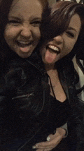 two women are sticking their tongues out and smiling