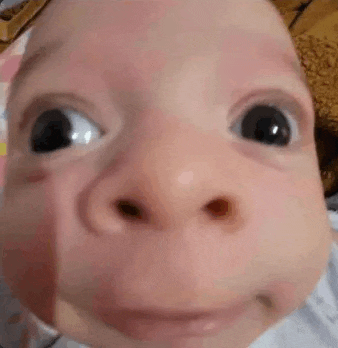 a close up of a baby 's face with a funny face .