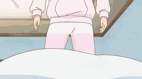 a girl in a pink hoodie and white pants is standing on a bed with her legs crossed .