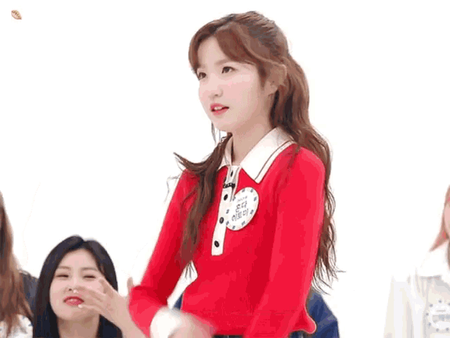 a girl in a red sweater is standing in front of a blue sign that says # 10-29