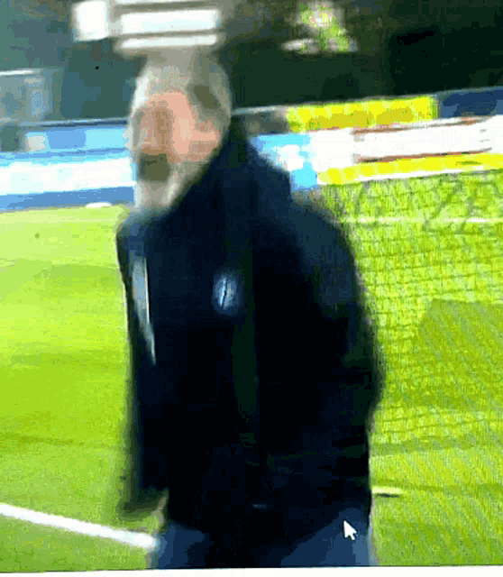 a blurry picture of a man on a soccer field with a arrow pointing to the right