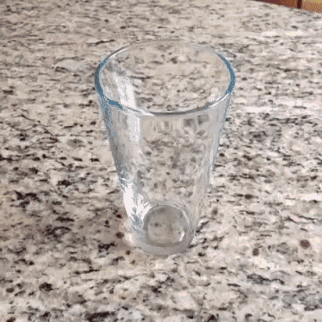 an empty glass is sitting on a granite counter