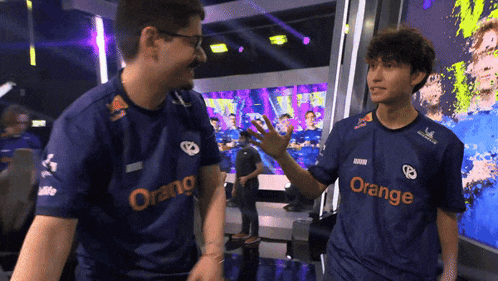 two men wearing blue shirts with orange on them