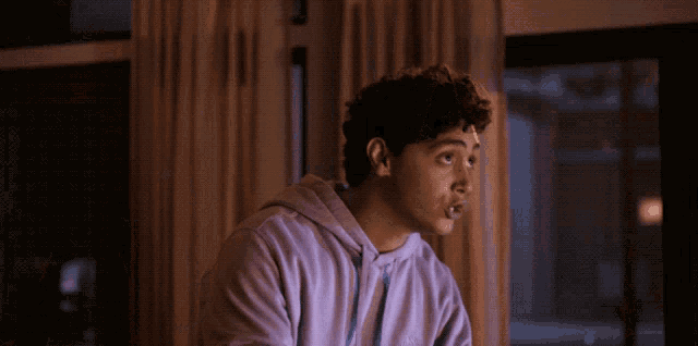 a young man wearing a purple nike hoodie looks surprised