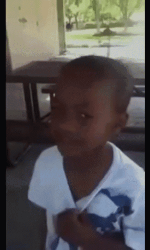 a young boy wearing a white shirt with a blue and white dolphin on it