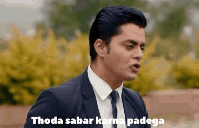 a man in a suit and tie with the words thoda sabar karna padega above him