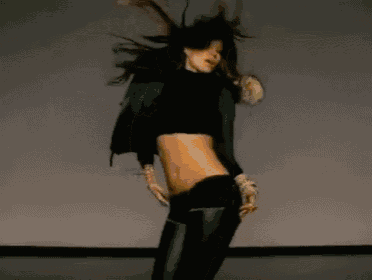 a woman wearing a fur hooded jacket is dancing on a stage