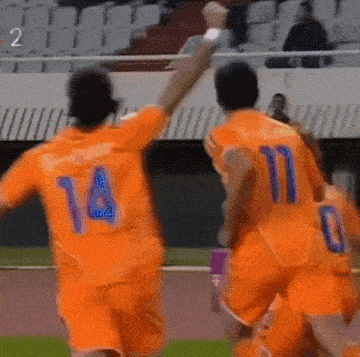 a soccer player with the number 14 on his back is celebrating