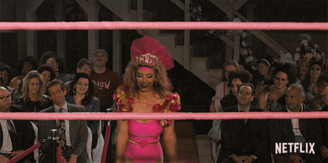 a woman in a pink outfit is standing in a wrestling ring with a netflix logo on the bottom