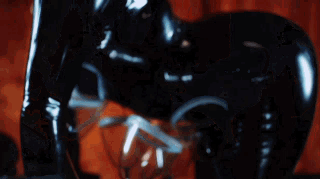 a woman wearing sunglasses and a black latex bodysuit