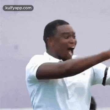 a man in a white shirt is making a funny face with his arms outstretched .